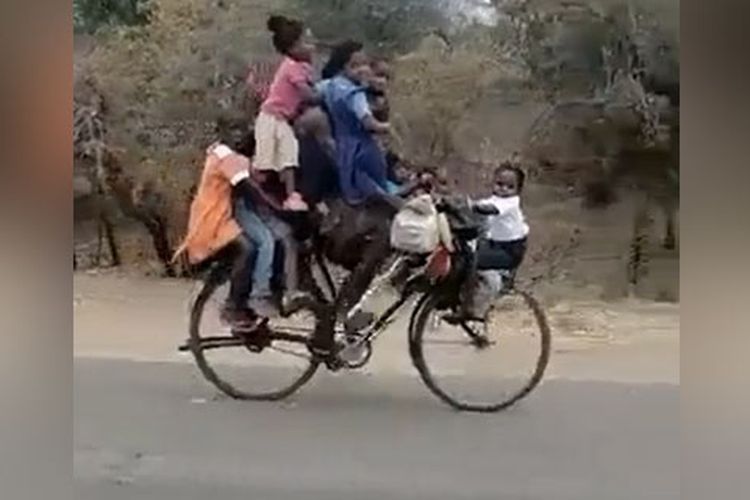 Pria India bersepeda dengan 9 anak.
