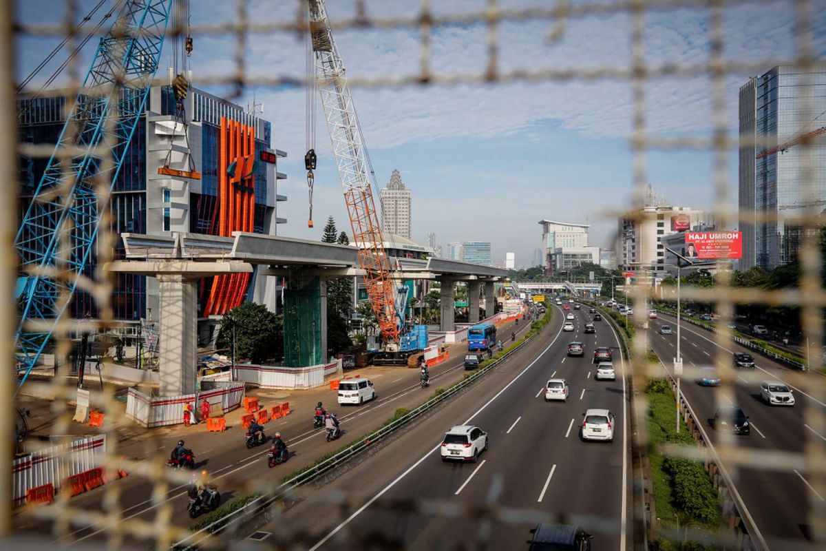 Pengendara melintas di samping lokasi pembangunan Light Rail Transit (LRT) Cawang-Pancoran di Jakarta, Sabtu (24/2/2018). Progres proyek pembangunan kereta api ringan atau Light Rail Transit (LRT) tahap I yang meliputi relasi Cibubur-Cawang, Bekasi Timur-Cawang dan Cawang-Dukuh Atas secara keseluruhan mencapai 20 persen dan ditargetkan selesai pada 2019.