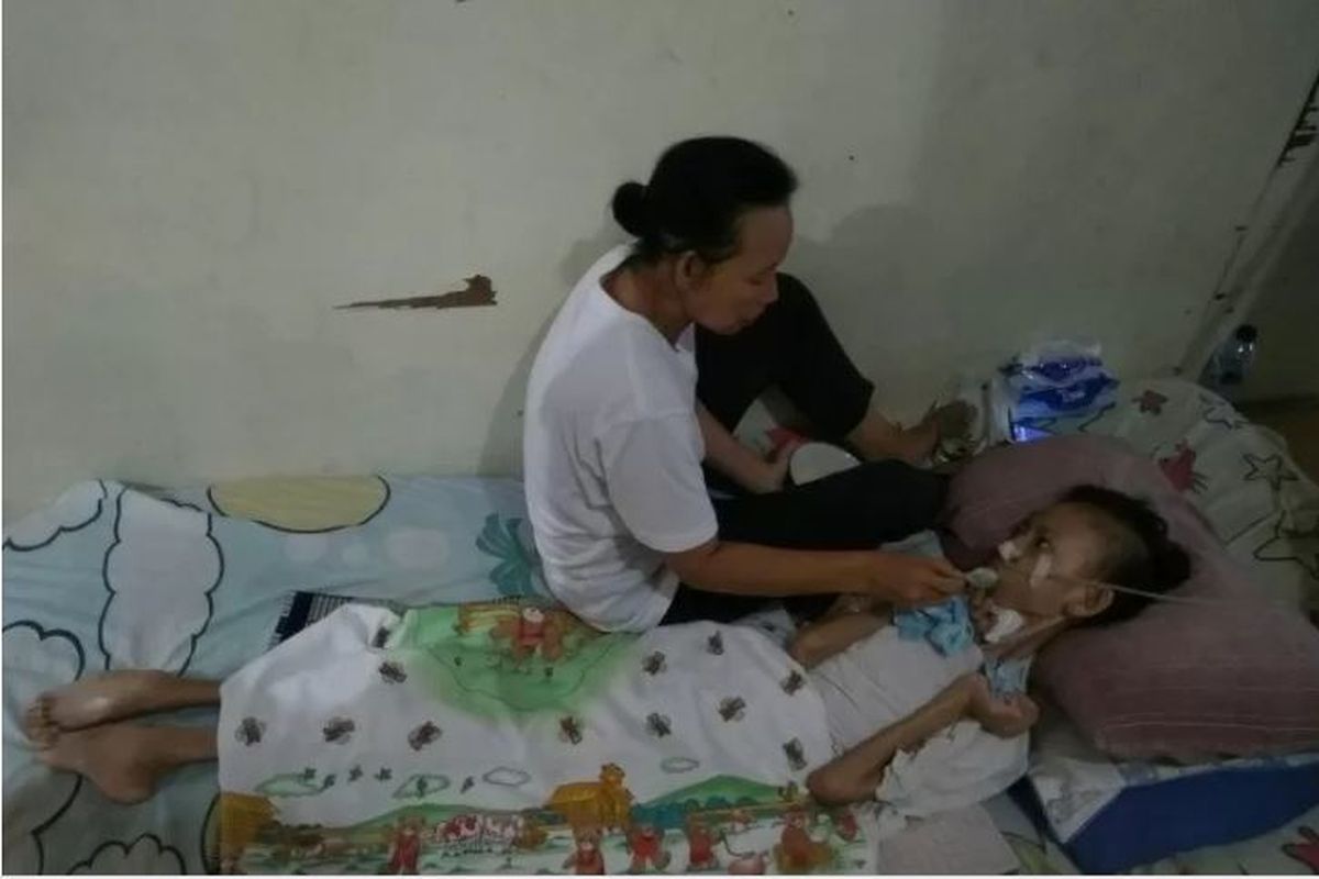 Panggah Jalu Panawe (14) mengalami pengeriputan otak, disuapi ibunya di rumahnya di Jalan Swadaya I, Pejaten Timur, Jakarta Selatan, Senin (25/11/2019) 