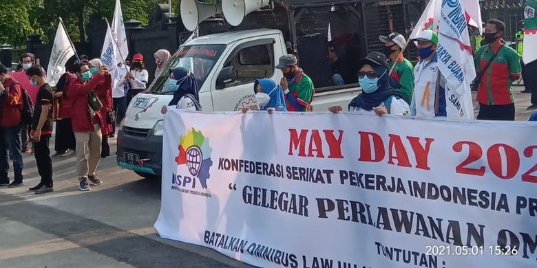 Workers stage a protest to mark international labor day in front of the office of the Central Java governor on Saturday, May 1, 2021.  