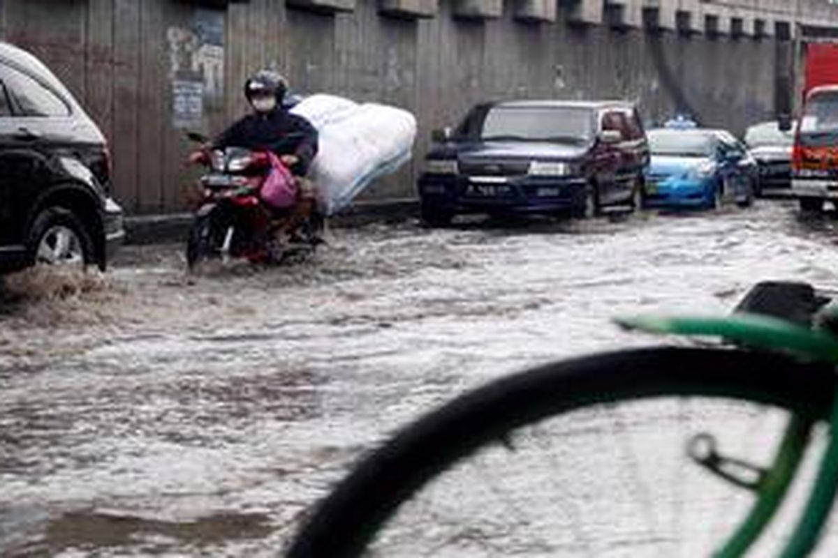 Kendaraan melintas di jalan yang tergenang air rob di Jalan RE Martadinata, Ancol, Jakarta, Rabu (5/1/2013). Tinggi muka air laut mengakibatkan rob di sejumlah jalan di kawasan tersebut, selain RE Martadinata juga jalan Gunung Sahari.
