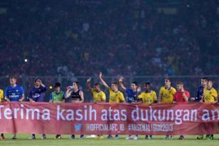 Pemain Arsenal memegang banner ucapan terima kasih kepada suporter usai bertanding melawan Indonesia Dream Team di Stadion Utama Gelora Bung Karno, Jakarta, MInggu (14/7/2013). Indonesia dicukur habis oleh Arsenal 0-7.