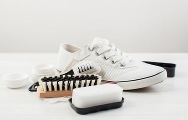 Ilustrasi membersihkan sepatu putih.