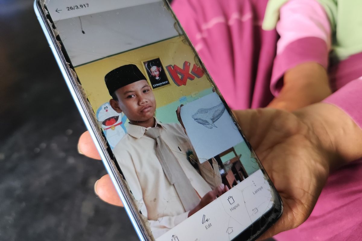 Sumilah (45) menunjukkan foto anaknya, Alif Riski Hanip Widodo (14) yang meninggal dunia setelah diduga dipukuli oleh pelatih silatnya, saat ditemui di rumah duka pada Rabu (25/9/2024).