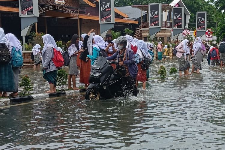 Seorang warga mendorong sepeda motornya melintasi banjir di Jalan Dr. Mansyur, Medan, Kelurahan Selayang I, Kecamatan Medan Selayang pada Kamis (18/8/2022).