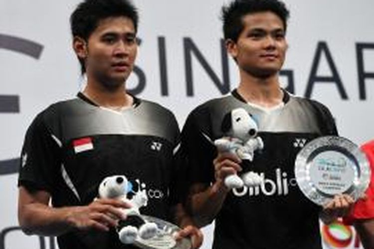 Pasangan ganda putra Indonesia, Angga Pratama (kiri)/Ricky Karanda Suwardi, berpose dengan status sebagai juara Singapura Terbuka setelah menundukkan pasangan Tiongkok, Fu Haifeng/Zhang Nan, pada laga final di Singapore Indoore Stadium, Minggu (12/4/2015). Angga/Rian menang 21-15, 11-21, 21-14.