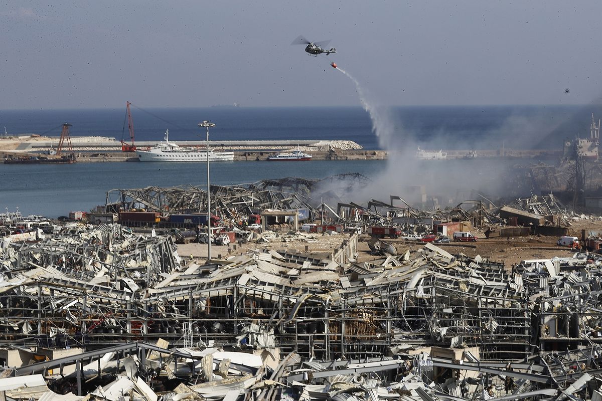 Sebuah helikopter menyiramkan air di lokasi kejadian di mana terjadi ledakan di pelabuhan Beirut, Lebanon, pada 5 Agustus. Warga setempat tersentak ketika terjadi ledakan pada Selasa (4/8/2020).