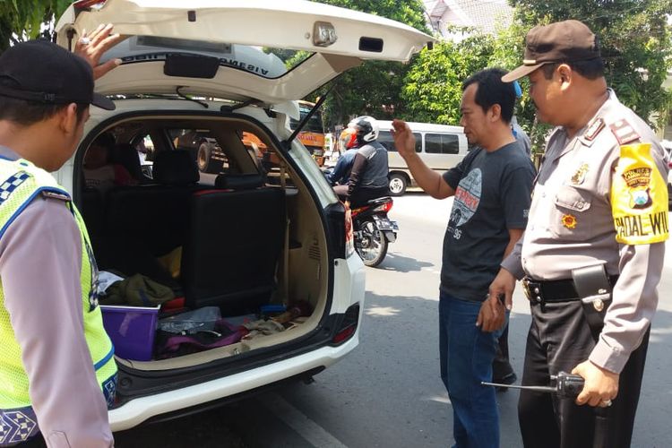 Petugas kepolisian di Lamongan saat memeriksa isi salah satu mobil, dalam razia menghadang massa berangkat hadiri people power di Jakarta.