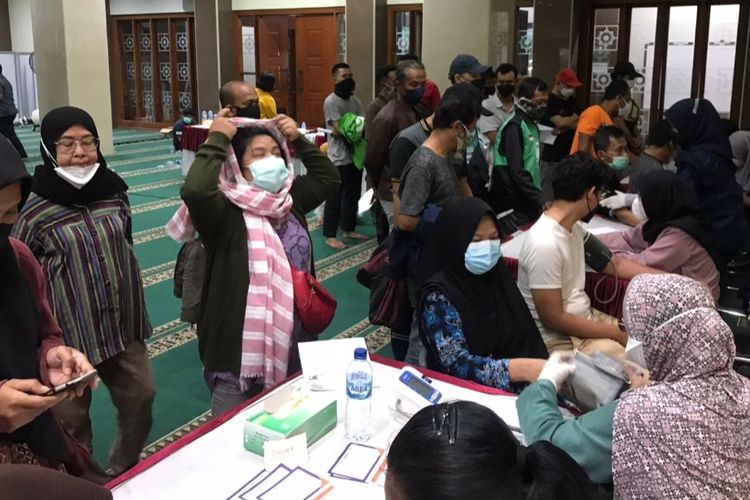 Suasana pelaksanaan vaksinasi booster malam hari yang dilakukan di Masjid Al-Wiqoyah, Jagakarsa, Jakarta Selatan pada Rabu (6/4/2022) malam.