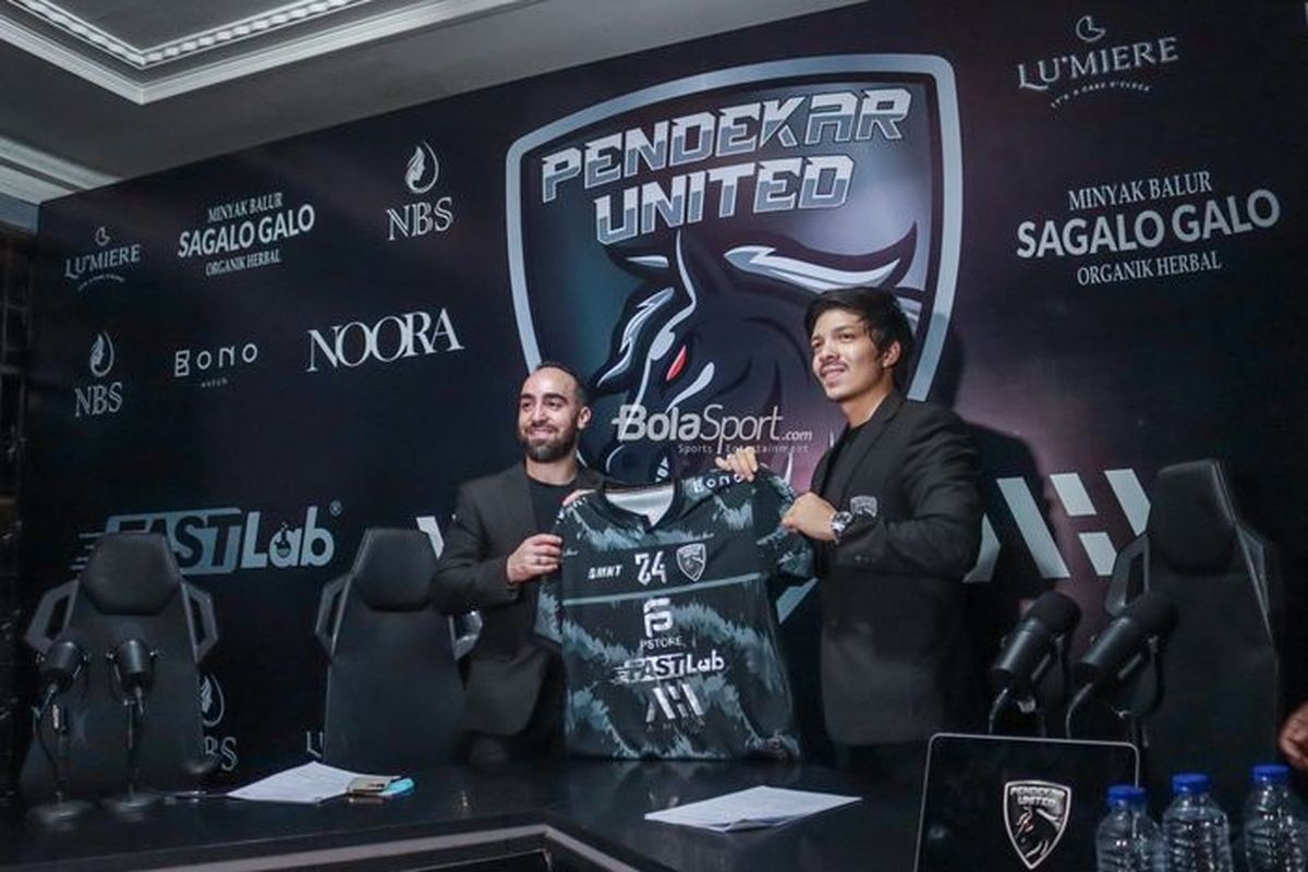 Pemilik klub futsal Pendekar United, Atta Halilintar (kanan), bersama dengan pemain baru yang merupakan bintang futsal dunia, Ricardinho, memegang jersey tim dalam acara perkenalan resmi Ricardinho sebagai pemain baru Pendekar United, Senin (13/6/2022) di markas tim di kawasan Pondok Indah, Jakarta Selatan.