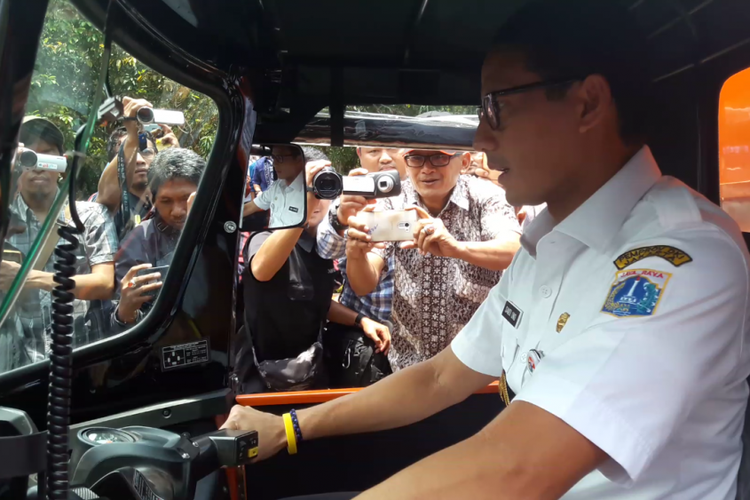 Wakil Gubernur DKI Jakarta Sandiaga Uno mengendarai alat angkut sampah motor roda tiga di Kantor Wali Kota Jakarta Utara, Rabu (14/3/2018).