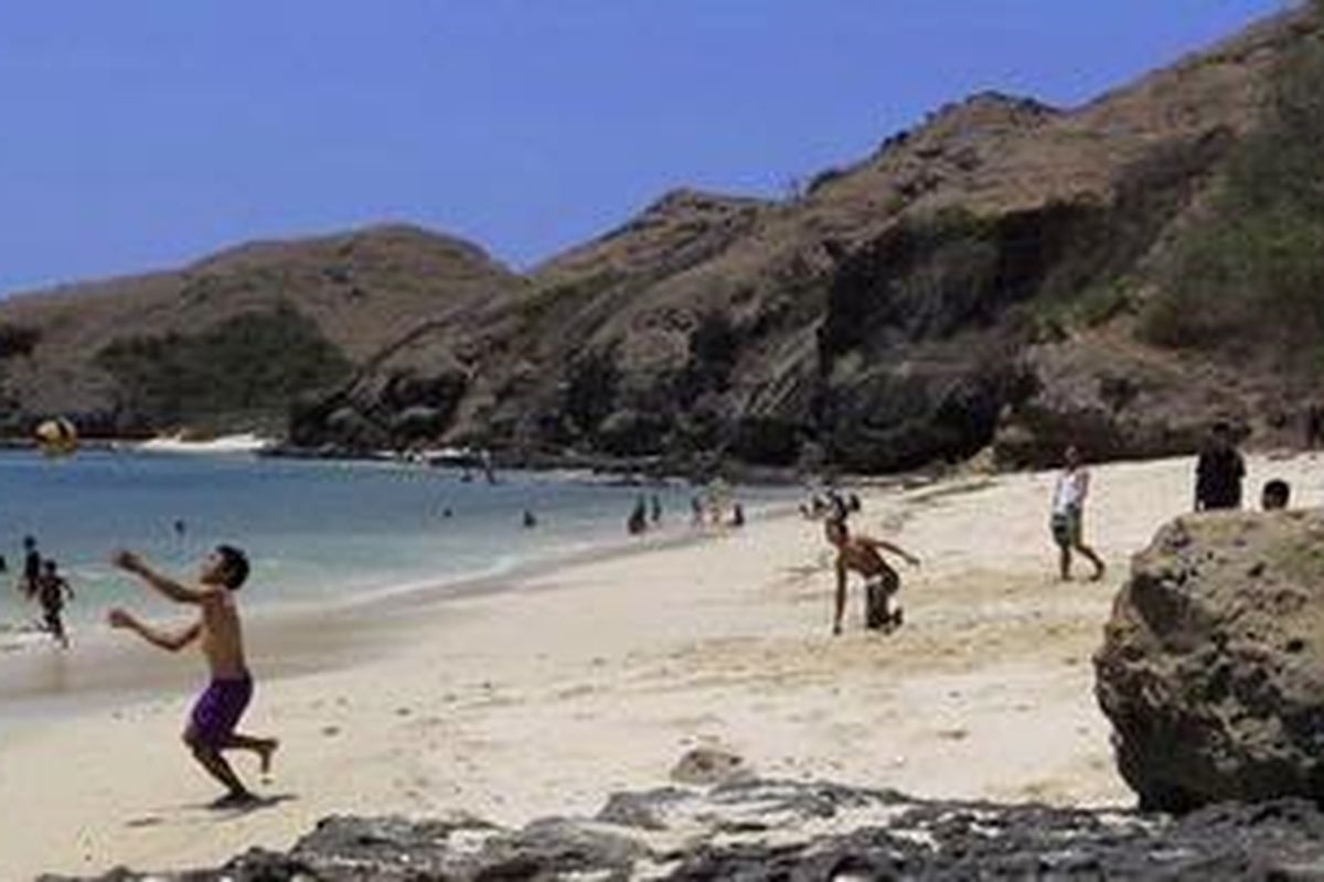 Warga berwisata di sekitar bukit batuan di Tanjung Aan, Pantai Kuta, Lombok Tengah, Nusa Tenggara Barat, Minggu (2/10/2011).  