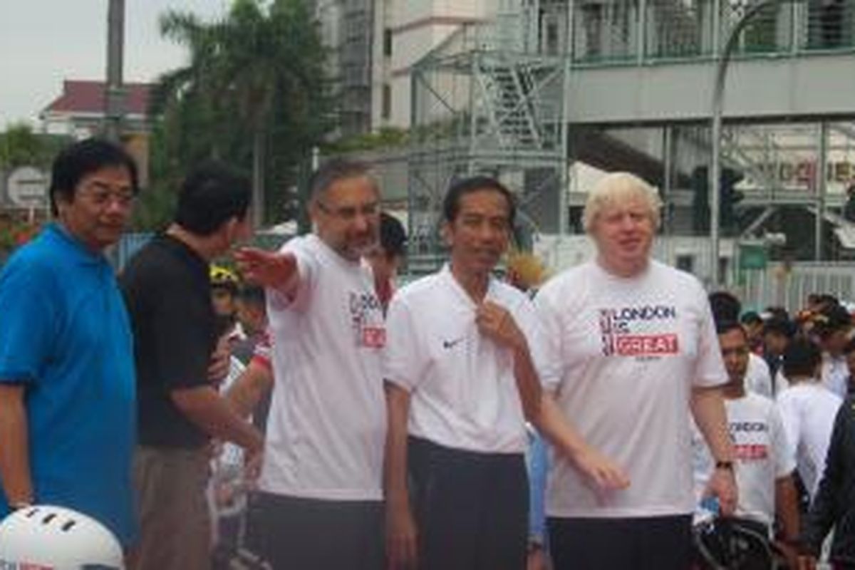 Presiden Joko Widodo (tengah di antara baju putih), dan Wali Kota London Boris Johnson (kanan) saat acara serah terima sepeda dari Pemkot London ke Pemprov DKI Jakarta, di Bundaran HI, Minggu (30/11/2014)