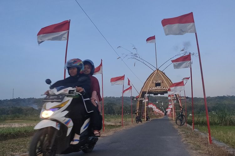 Ribuan bendera Merah Putih berkibar di jalan yang membelah area sawah Pedukuhan Dobangsan, Kalurahan Giripeni, Kapanewon Wates, Kabupaten Kulon Progo, Daerah Istimewa Yogyakarta. Warga mayoritas petani selalu menyambut peringatan kemerdekaan RI dengan mengibarkan bendera seperti ini selama satu bulan penuh