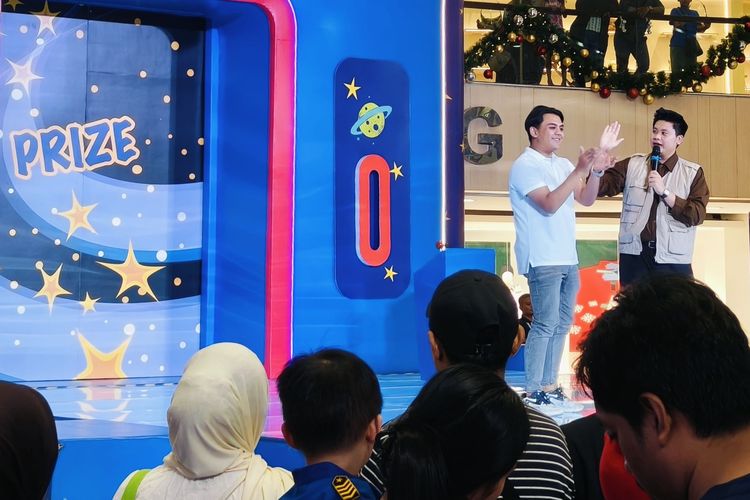 Salah satu pengunjung Matheuw Zein saat menjawab kuis dari MC sebelum foto bersama dua karakter dalam film Toy Story, Woody dan Buzz Lightyear dalam meet and greet yang digelar di Tunjungan Plaza 3 Surabaya, Kamis (18/12/2025) malam.