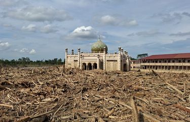 Masjid di asrama putra Pondok Pesantren Darul Mukhlisin Aceh Tamiang masih berdiri kokoh di antaranya tumpukan kayu yang terbawa arus banjir dan tanah longsor, Jumat (13/12/2025).