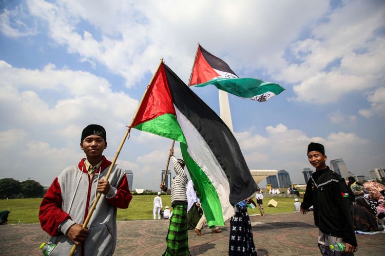 Umat Islam mengibarkan bendera Palestina saat mengikuti aksi Solidaritas Baitul Maqdis di lapangan Monumen Nasional, Jakarta Pusat, Jumat (11/5/2018). Aksi solidaritas Baitul Maqdis digelar untuk menyoroti konflik antara Palestina dan Israel yang berakar pada perebutan bangunan suci atau Baitul Maqdis dan menolak keputusan pemerintah Amerika Serikat yang memindahkan Kantor Kedutaaan Besar AS untuk Israel ke Yerusalem.