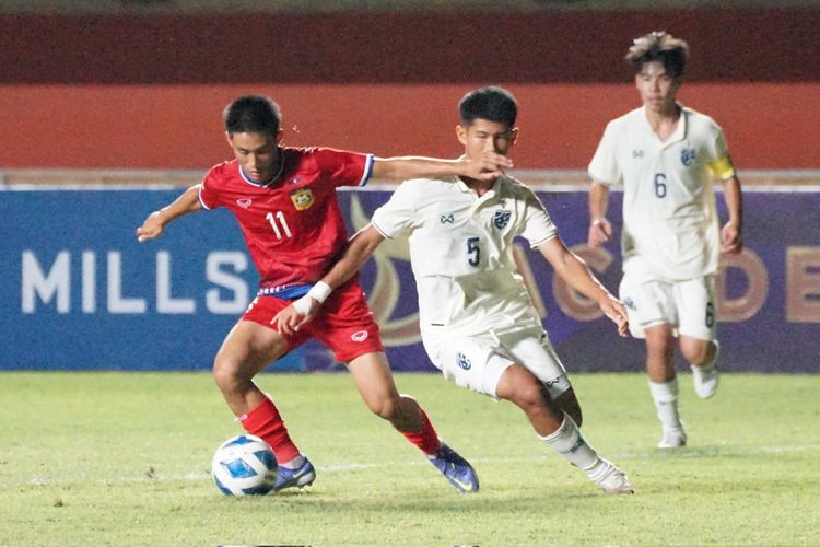 Thanousack Nanthavongdouangsy (kiri) berebu bola dengan Jirapol Saelio (kanan) pada laga Grup B Piala AFF U16 2022 yang mempertemukan Laos vs Thailand di Stadion Maguwoharjo, Kamis (4/8/2022).