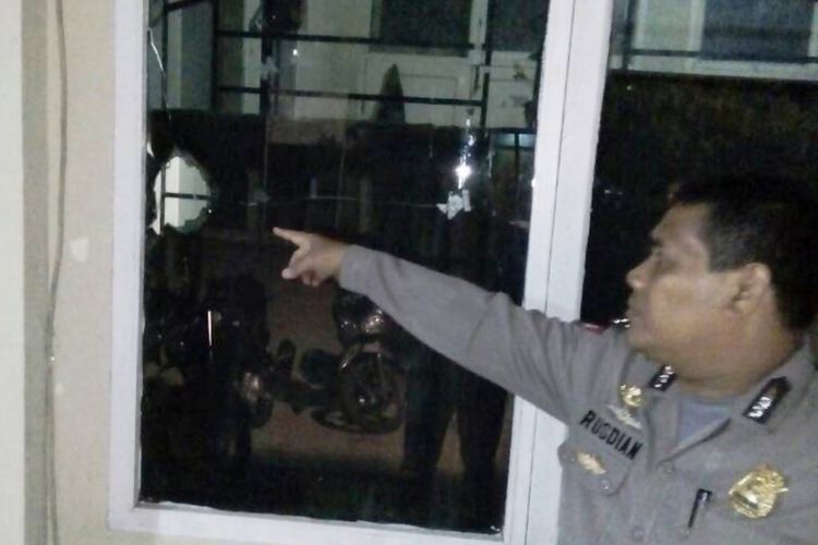 Polisi menunjukan kaca pecah di kantor Satpol PP dan WH, Lhokseumawe, Kamis (22/6/2017)
