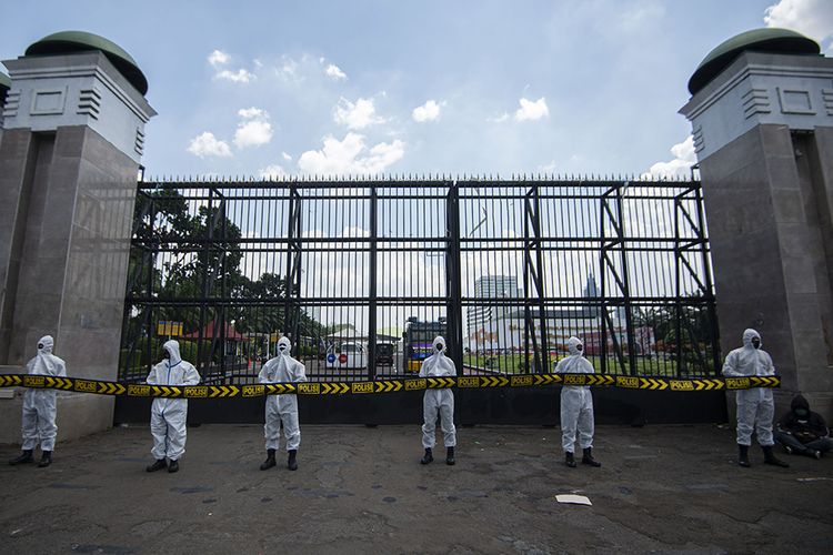 Polisi mengenakan masker dan pakaian hazmat saat mengamankan unjuk rasa penolakan buruh terhadap Omnibus Law Rancangan Undang-Undangan (RUU) Cipta Kerja di depan kompleks Parlemen, Jakarta, Rabu (30/9/2020). Penggunaan pakaian pelindung diri tersebut dilakukan sebagai antisipasi polisi terhadap penularan Covid-19 selama pengamanan terhadap pengunjuk rasa.