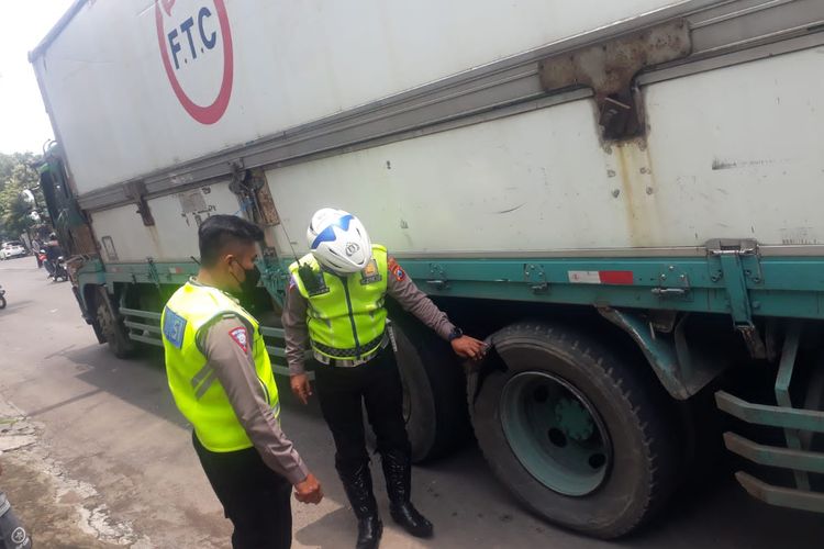 Polantas tengah memeriksa ban truk tronton yang pecah di Jl Teuku Umar Kota Kediri, Jawa Timur, Kamis (20/10/2022).