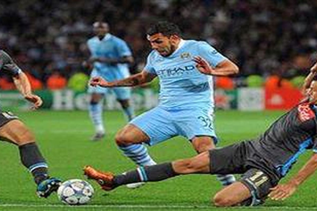 Striker Manchester City, Carlos Tevez, dihadang para pemain Napoli pada pertarungan Liga Champions Grup A, Rabu atau Kamis (15/9/2011) dini hari WIB. City akhirnya ditahan Napoli 1-1.