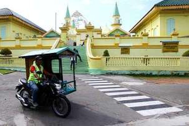 Becak motor melintas di Masjid Raya Sultan Riau atau dikenal sebagai Masjid Penyengat di Tanjung Pinang, Kepulauan Riau. Untuk berkeliling Pulau Penyengat, alternatif transportasi utama adalah becak motor. 
