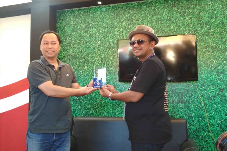 Perwakilan Wami memberikan penghargaan kepada CEO Rajawali Indonesia Communication Anas Syahrul Alimi (kanan) karena telah memenuhi hak cipta lagu di setiap konser, Minggu (19/8/2018)