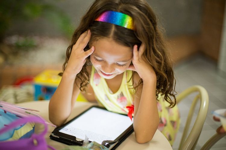 Ilustrasi anak membaca buku digital.