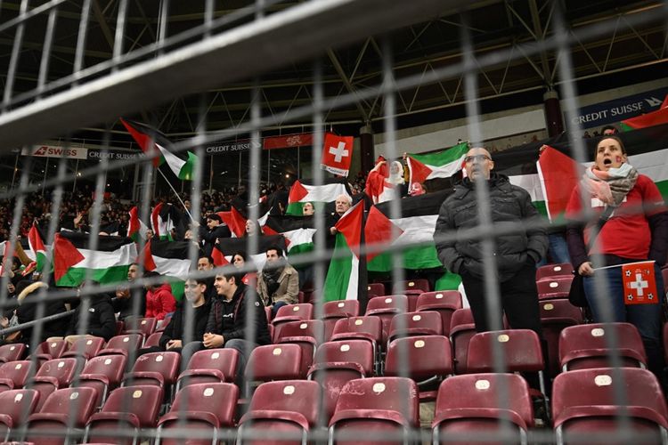 Suporter terlihat mengibarkan lusinan bendera Palestina pada laga Swiss vs Israel di ajang Kualifikasi Piala Eropa 2024 pada Rabu (29/3/2023) dini hari WIB.