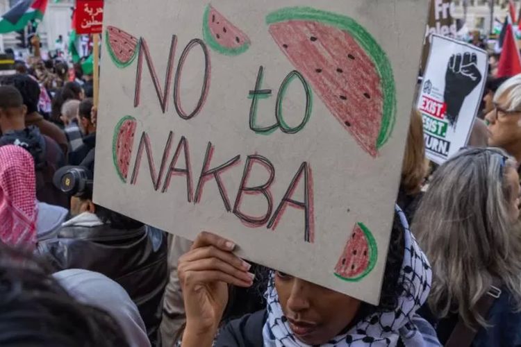 Seorang demonstran pro-Palestina memegang tanda bertuliskan Tidak untuk Nakba dalam unjuk rasa mendukung penduduk Palestina di Gaza pada 14 Oktober 2023 di London, Inggris.