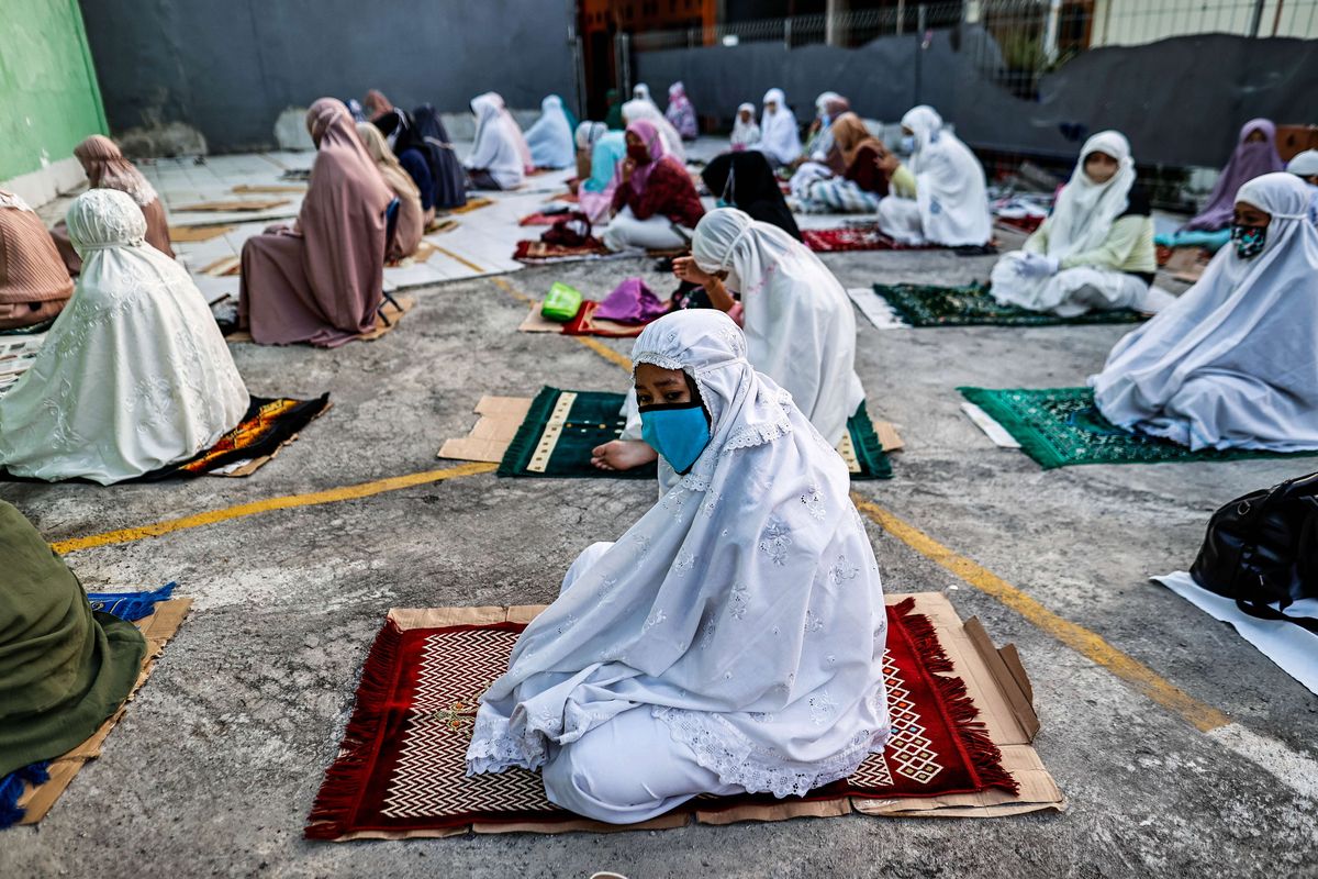 Umat muslim melaksanakan shalat Idul Adha di Jalan Pramuka Raya, Cempaka Putih, Jakarta Timur, Jumat (31/7/2020). Umat muslim menggelar shalat Idul Adha secara berjamaah dengan menerapkan protokol kesehatan seperti jaga jarak serta wajib mengenakan masker guna mencegah penyebaran COVID-19.