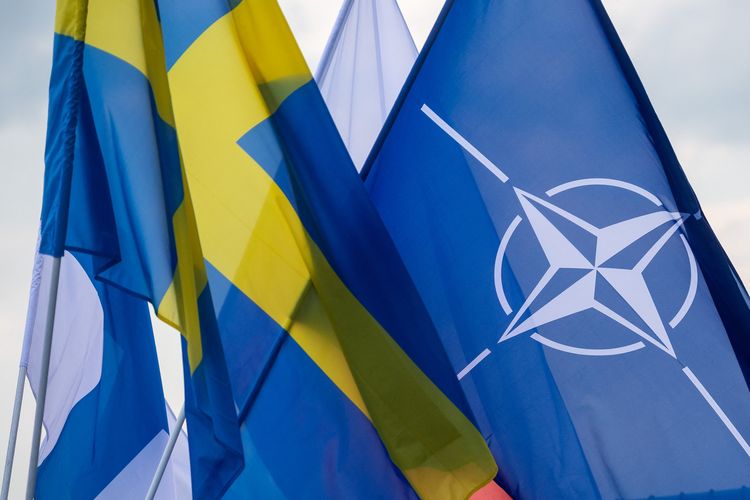 Bendera Polandia, Swedia, Finlandia, dan NATO berkibar saat proses ratifikasi Finlandia dan Swedia gabung NATO. Proses Swedia dan Finlandia gabung NATO menyudahi sejarah non-blok militer mereka, dan terjadi setelah invasi Rusia ke Ukraina pada akhir Februari 2022.