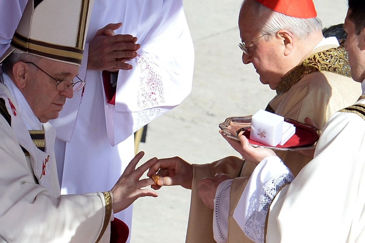 Kardinal Italia Angelo Sodano (kanan) mengenakan Cincin Nelayan, yang terbuat dari perak berlapis emas, di jari Paus Fransiskus selama misa pelantikannya yang megah pada 19 Maret 2013 di Lapangan Santo Petrus, Vatikan.