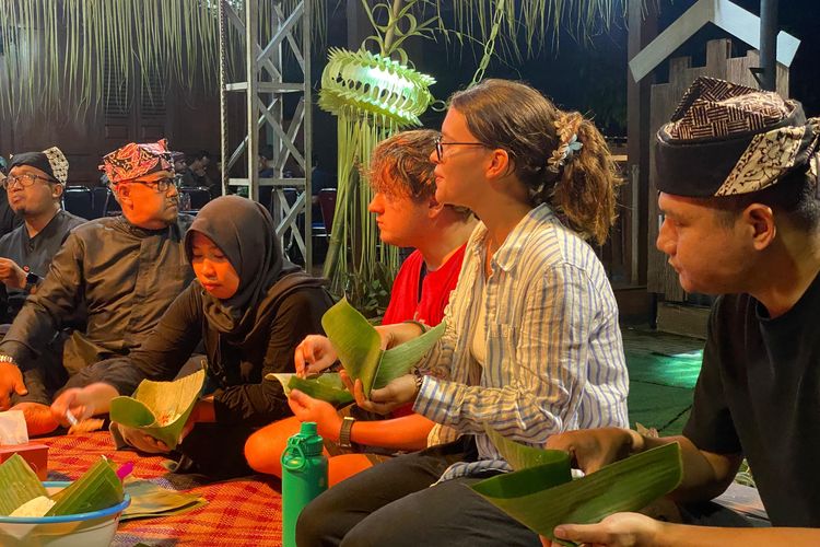 Wisatawan mancanegara menikmati hidangan tumpeng di acara Tumpeng Sewu Desa Kemiren Banyuwangi, Kamis (29/5/2025) 