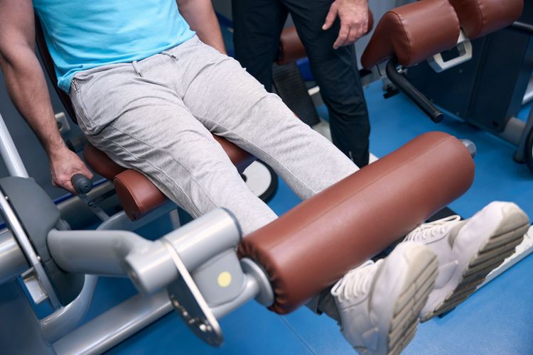 Ilustrasi menggunakan seated leg extension machine di tempat gym.
