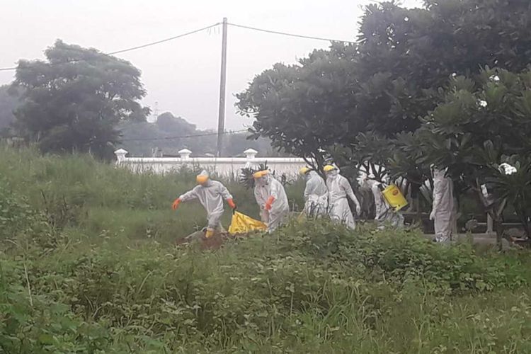 Tim tengah memakamkan jenazah pasien Covid-19 di Karawang.