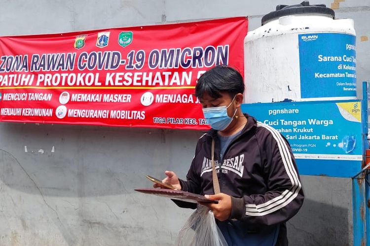 Kurir ekspedisi, Ferdi Dapitra (21) bingung jika mengantar paket khusus ke warga di wilayah micro lockdown seperti di RW 02 Keukut, Tamansari, Jakarta Barat, Sabtu (15/1/2022). 