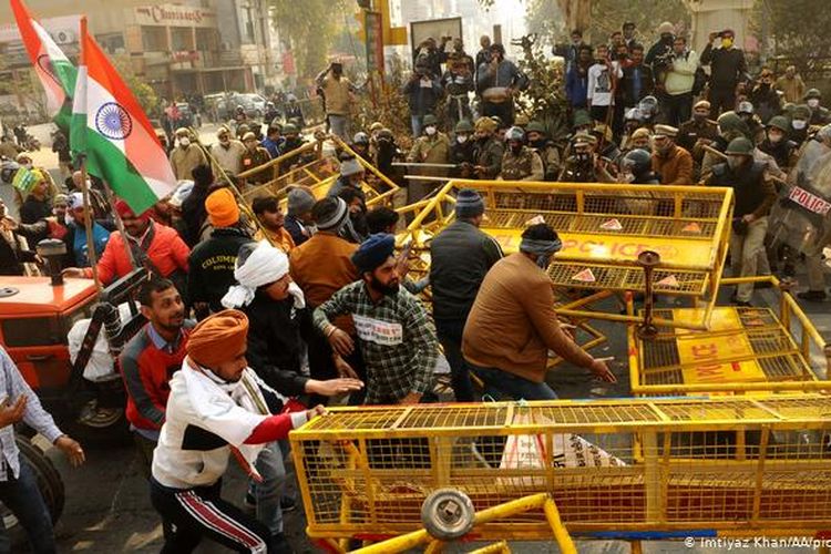 Aksi para petani membongkar blokade polisi menuju pusat kota New Delhi, India, Selasa (26/1/2021).