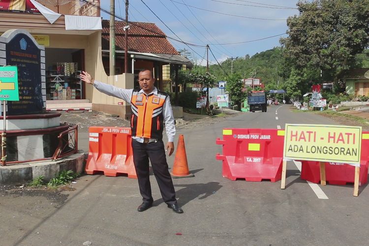 Petugas Dinas Perhubungan Kabupaten Kuningan mangatur arus lalu lintas di titik peralihan, Selasa siang (9/4/2019). Seluruh kendaraan tidak dapat melintas jalur nasional Kuningan - Cikijing karena tertutup longsor sebanyak delapan titik. Para pengendara harus melintasi jalur alternatif yang disediakan. 