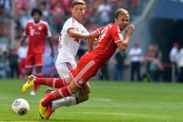 Gelandang Bayern Muenchen, Mario Goetze (kanan), dilanggar pemain Nuernberg, Niklas Stark, saat kedua tim bertemu dalam lanjutan Bundesliga 1, Sabtu (24/8/2013).  