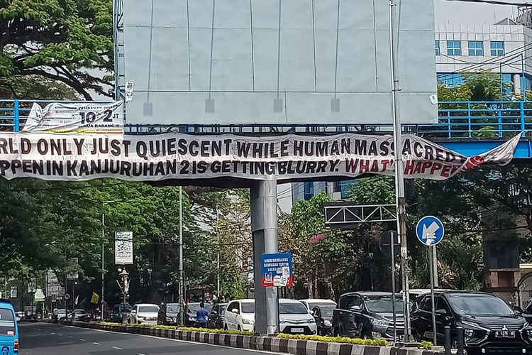 Banner panjang mengingatkan soal Tragedi Kanjuruhan terpasang di Jembatan Penyeberangan Orang di Jalan Ahmad Yani, Kota Malang pada Senin (24/7/2023). 