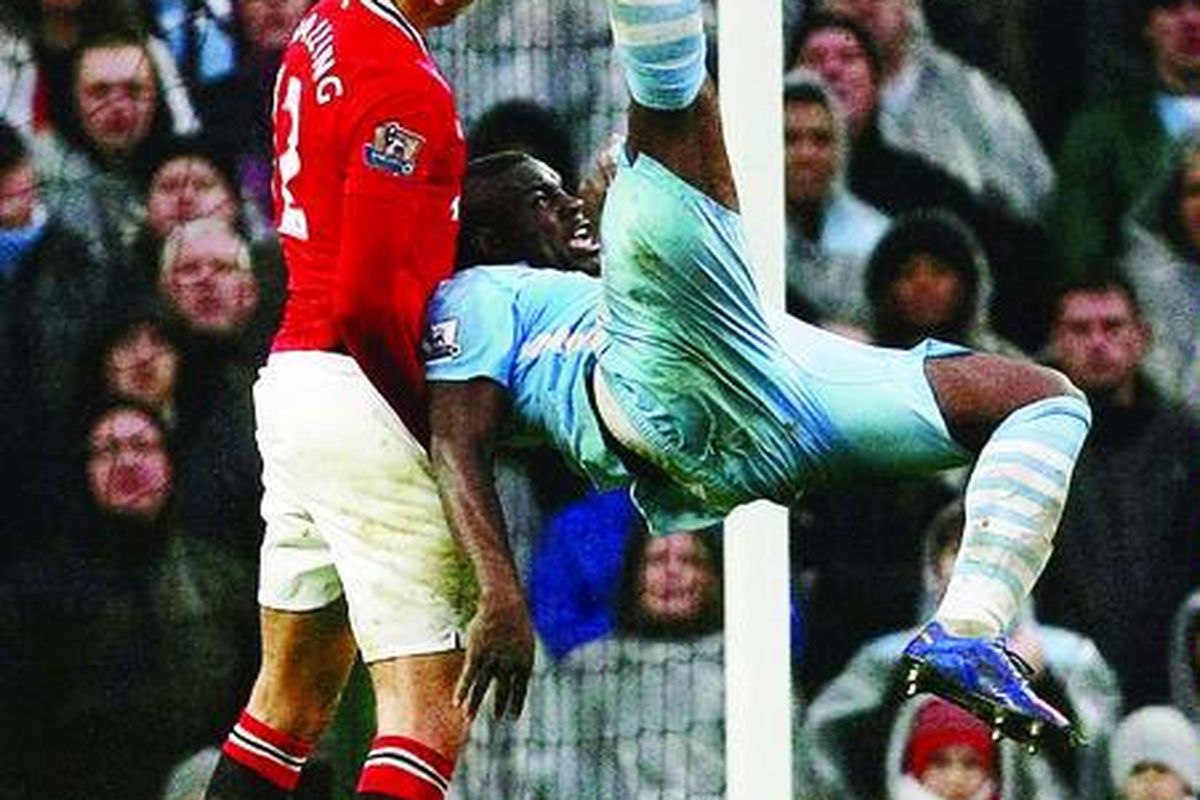 Bek Manchester City, Micah Richards (kanan), berduel dengan Chris Smalling (Manchester United) dalam laga Piala FA di Stadion Etihad, Manchester,  Minggu lalu. Sabtu (14/1) ini MU bertarung melawan Bolton Wanderers  di Liga Primer.