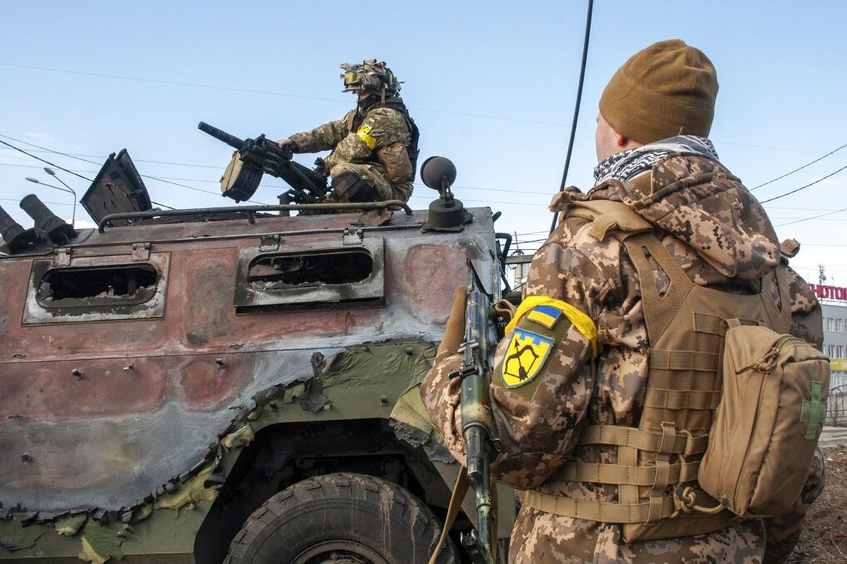 Tentara Ukraina memeriksa kendaraan militer yang rusak setelah pertempuran di Kharkiv, Ukraina, Minggu (27/2/2022). Pemerintah kota mengatakan bahwa pasukan Ukraina terlibat dalam pertempuran dengan pasukan Rusia yang memasuki kota terbesar kedua di negara itu pada Minggu.