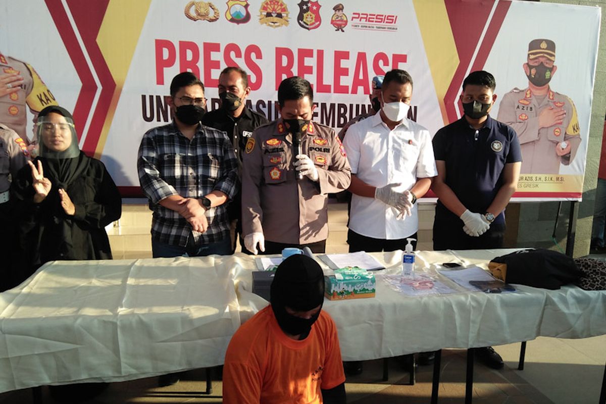 Tersangka (duduk) dugaan pembunuhan mayat wanita yang ditemukan terbungkus tas, saat dihadirkan dalam rilis pengungkapan kasus di halaman Mapolres Gresik, Senin (12/9/2022) sore WIB.