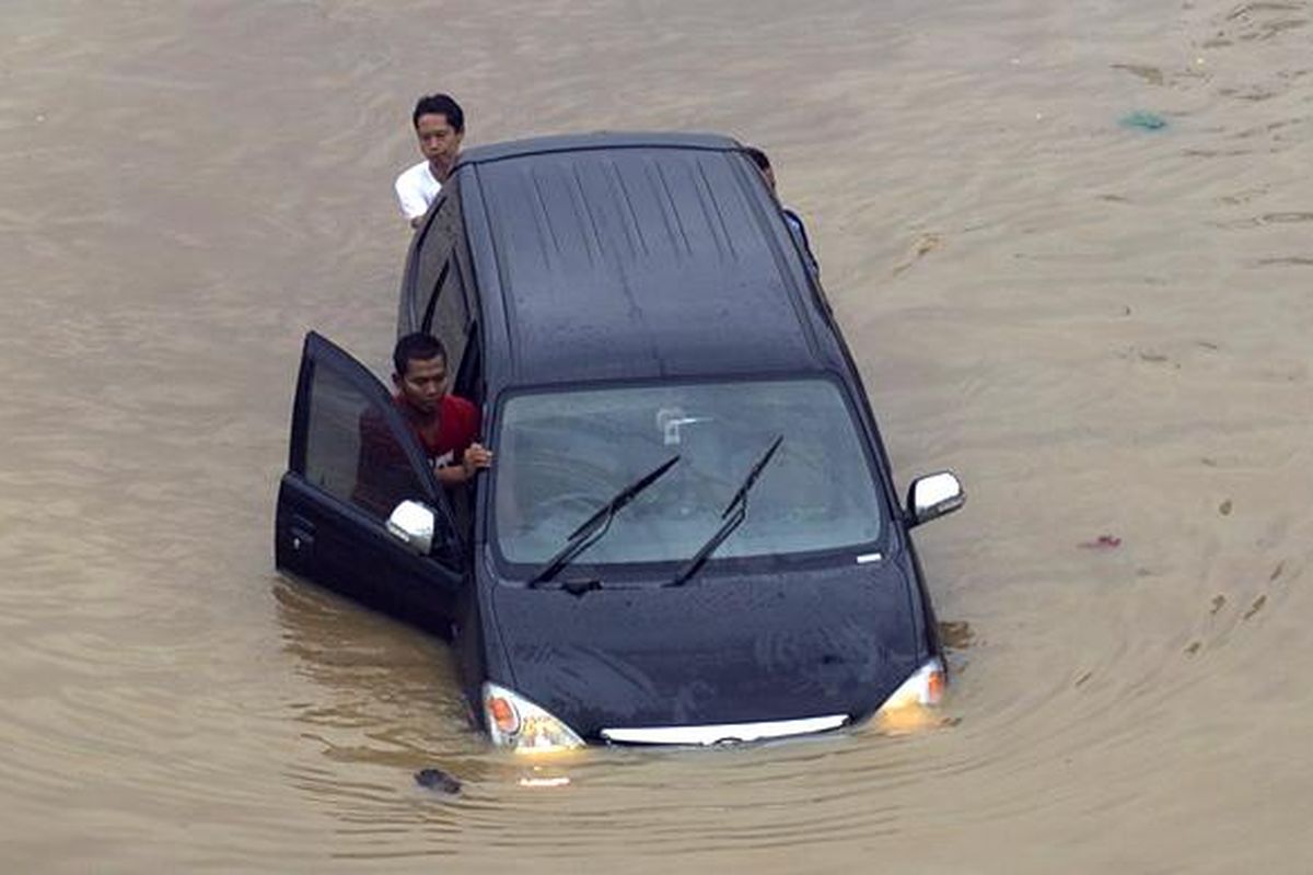 Caption : Luapan Kali Ciliwung memutus jalur kendaraan di Jalan KH Abdullah Syafiie, Tebet, Jakarta Selatan, Senin (13/1/2014). Luapan kali mulai menggenangi permukiman dan memutus jalan sejak Senin dini hari. KOMPAS/AGUS SUSANTO 