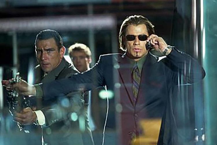 Aksi John Travolta dalam film Swordfish (2001) yang akan tayang di Netflix 1 Agustus 2020 mendatang.
