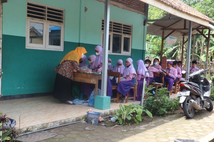 Siswa kelas 6 MI Roudlotul Muttaqin di Desa Penompo, Kecamatan Jetis, Kabupaten Mojokerto, Jawa Timur, belajar di teras sekolah, Kamis (18/11/2021).
