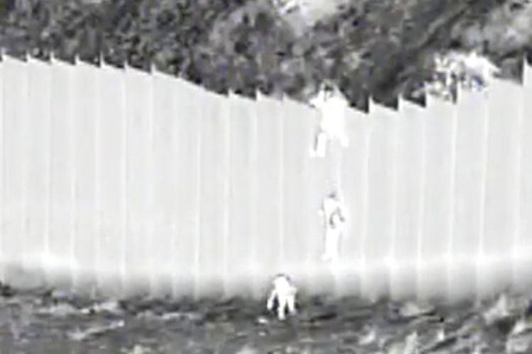 Bea Cukai dan Perlindungan Perbatasan AS menunjukkan penyelundup menjatuhkan anak-anak dari atas penghalang perbatasan di Santa Teresa.