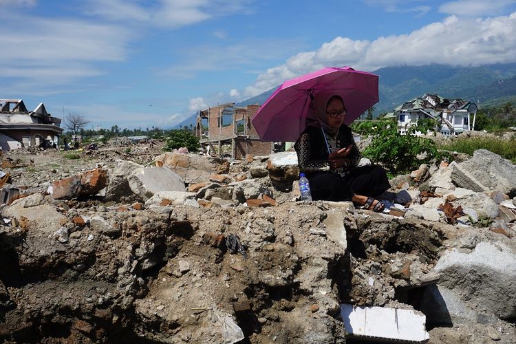 Warga berdoa di tempat hilangnya anggota keluarga mereka di lokasi bekas terdampak likuefaksi di Kelurahan Balaroa, Palu, Sulawesi Tengah, Rabu (5/6/2019). Usai melaksanakan shalat Idul Fitri, umat muslim korban bencana mendatangi lokasi permukiman penduduk yang hancur akibat gempa dan likuefaksi tersebut untuk mengenang dan mendoakan keluarga mereka yang meninggal dunia atau dinyatakan hilang dalam peristiwa tersebut. ANTARA FOTO/Mohamad Hamzah/hp.                             